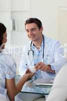 Male doctor giving pills to a female patient