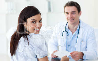 Male doctor giving a prescription to his patient