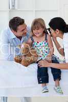 Female doctor checking smiling girl's ears