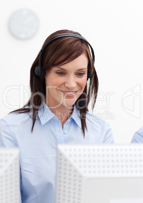 Young businesswoman with headset on in a call center