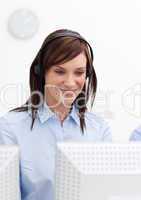 Young businesswoman with headset on in a call center