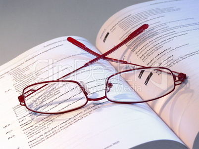 Brille auf einem Buch mit medizinischen Ausdrücken