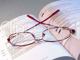 Brille auf einem Buch mit medizinischen Ausdrücken