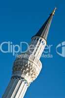 Klassischer Moscheebau Minarett in weiss vor blauem Himmel
