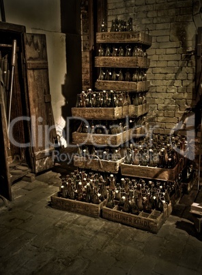Bierflaschen in Bierkästen gestapelt im Keller in Sepia
