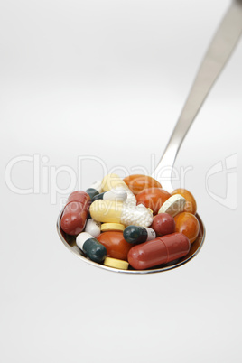 Bunte Tabletten auf Löffel