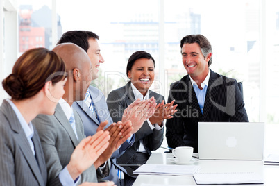 Smiling multi-ethnic business team applauding