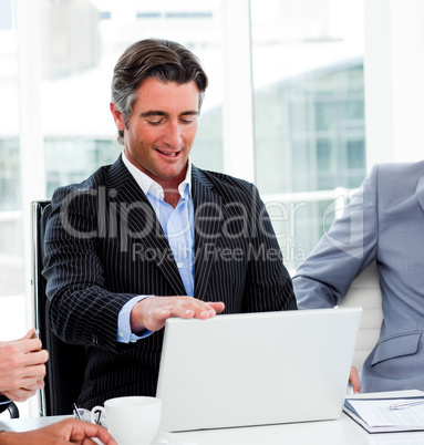 Portrait of a confident businessman using a laptop
