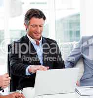 Portrait of a confident businessman using a laptop