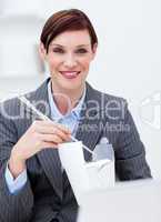 Businesswoman eating chinese food at work