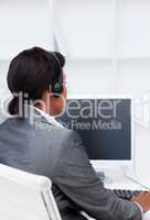 Smiling businesswoman working at a computer in a call center