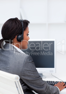 Serious businesswoman working at a computer with headset on