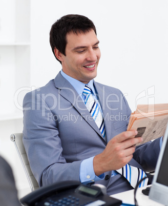 Attractive young businessman reading a newspaper