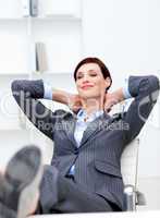 Businesswoman sitting in office with feet on desk relaxing