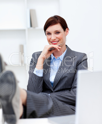 Attractive businesswoman leaning feet on desk