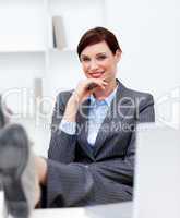 Attractive businesswoman leaning feet on desk