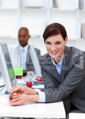 Smiling businesswoman at work with her colleague in the backgrou