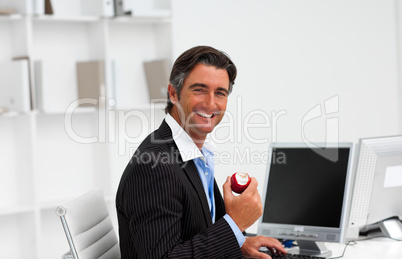 Businessman eating a fruit at work