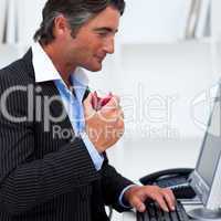 Close-up of a happy businessman eating a red apple