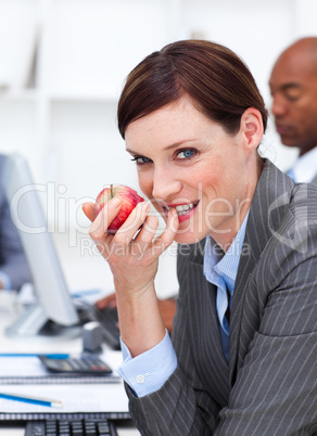 Businesswoman eating a fruit at work