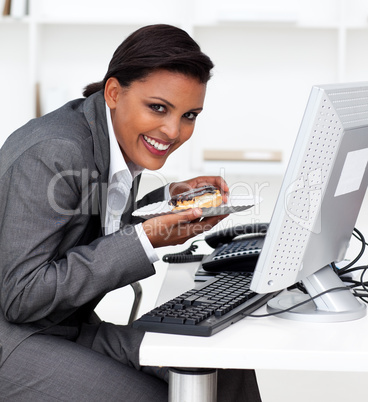 Smiling businesswoman eating a pastry