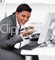 Smiling businesswoman eating a pastry