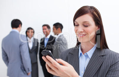 Smiling manager sending a text with a mobile phone