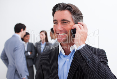 Attractive manager on phone with his team in the background