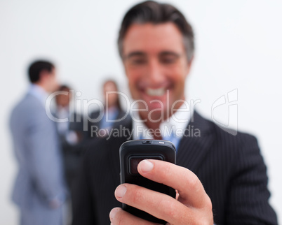Smiling businessman sending a text with a mobile phone