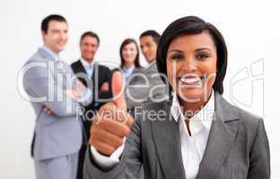 Attractive female executive smiling at the camera with thumb up