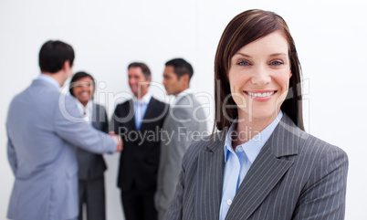 Smiling female executive with her team in the background