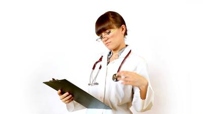 Female doctor recording something on notepad and prohibit