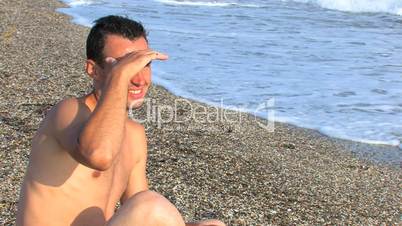 HD young man sitting on the beach