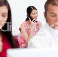Asian businesswoman on phone with her colleagues in the foregrou