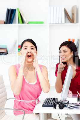 One businesswoman yelling and one businesswoman asking for silen