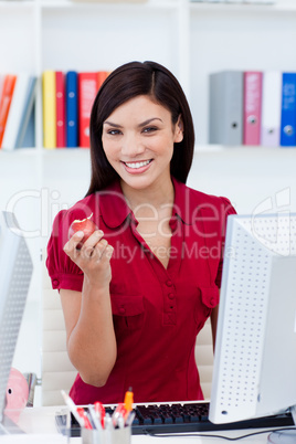 Young businesswoman eating a fruit