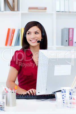 Confident female executive with headset on at her desk