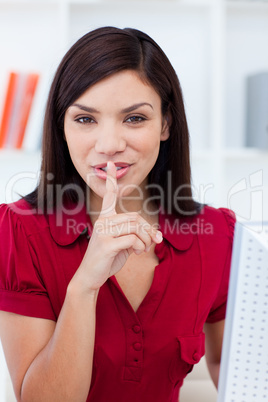Confident businesswoman showing quiet sign at work