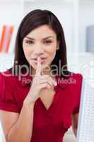Confident businesswoman showing quiet sign at work