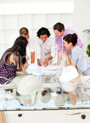 A team of architects at the meeting looking at blueprints