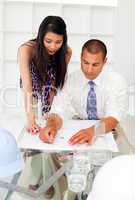Two architects discussing a construction plan in the office