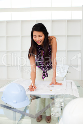 Portrait of a female architect studying plans