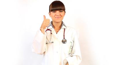Young woman doctor smiles and shows thumb up