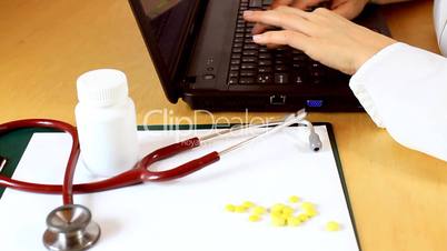 Close up of doctor hands typing on laptop