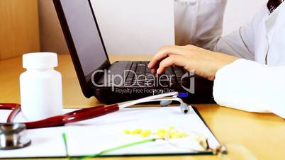 Close up of doctor hands typing on laptop