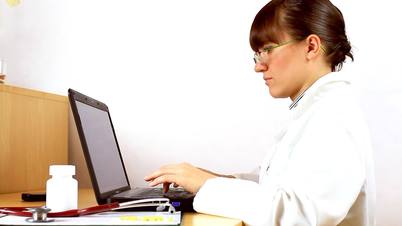 Female doctor typing on laptop and check medications