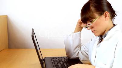 Tired doctor asleep in front of laptop