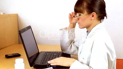 Tired female doctor in front of laptop