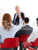 Businesswoman raising her hand up at a conference