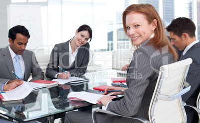 Smiling businesswoman in a meeting with her team